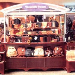 Custom sales kiosk or RMU displays and sells handbags, leather goods