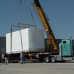 Factory manufactured building loaded by crane for truck transport