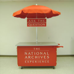 Small outdoor information booth cart with umbrella