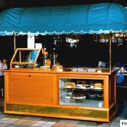 Foodservice coffee and bakery cart with pastry display window in a retail center